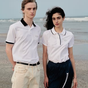 白いポロシャツを着る海辺の2人