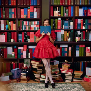 赤いドレスを着た女性が図書館で楽しんでいる様子