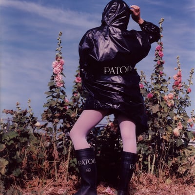 「パトゥ」が「ルシャモー」とコラボレーションした黒のラバーブーツを着用したモデル