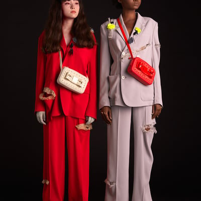 ファッションブランド「アンダーカバー」がブラジル発のブランド「メリッサ」と製作した赤とグレーのスーツを着用した男女