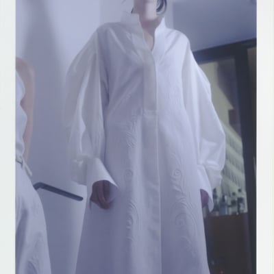 マメ クロゴウチの白いワンピースを着た女性モデル