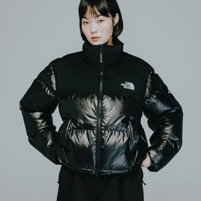 ザ・ノース・フェイスのダウンジャケットを着用した女性