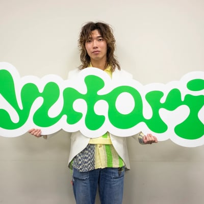 yutoriのロゴパネルを持った片石貴展代表