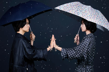 傘をさし手を合わせる男女2人