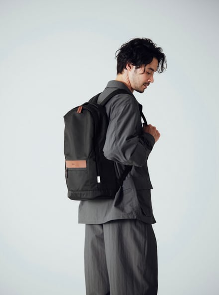 土屋鞄製造所の新作リサイクルナイロン製バックパックを持つ男性