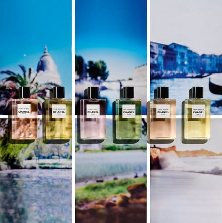 パリの風景をバックに、色とりどりの香水が並んでいる画像
