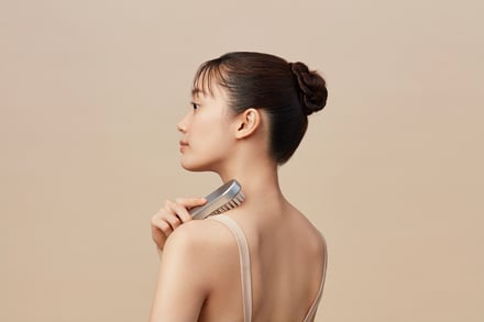 美容電気ブラシを肩に当てている女性の画像