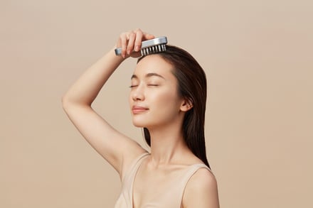 美容電気ブラシを頭に当てている女性の画像