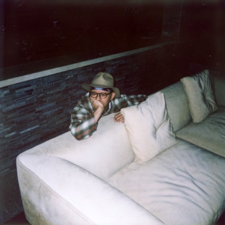 ソファーに頬杖をつく男性のフィルム写真