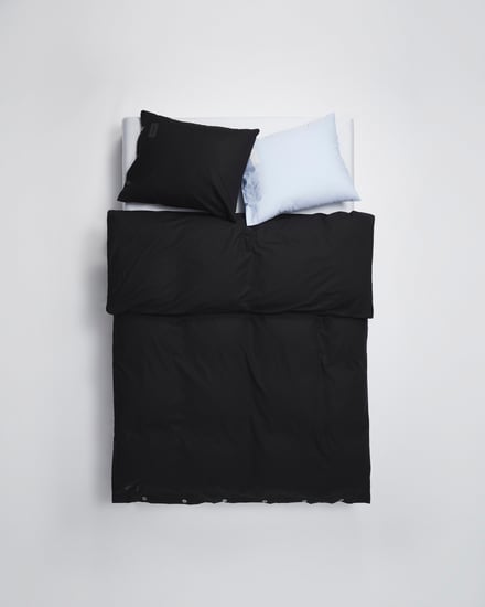 黒いシーツカバーと黒と白のピローケースを使用したベッドベッド