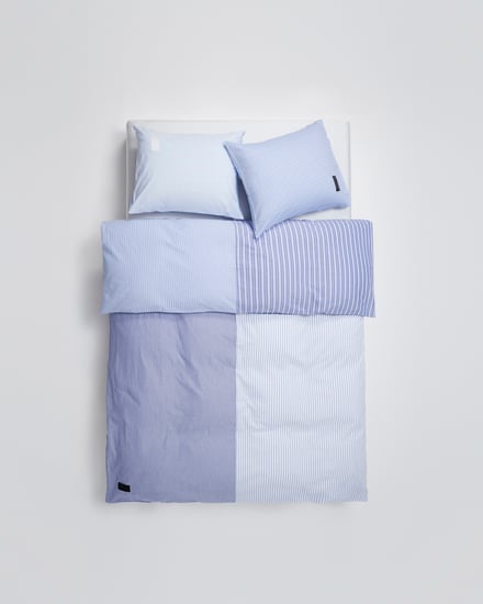 青と水色のシーツカバーと水色のピローケースを使用したベッドベッド