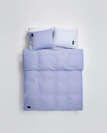青いシーツカバーと青と水色のピローケースを使用したベッドベッド