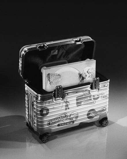 グレーのステッカーロゴをあしらったシルバーのスーツケース