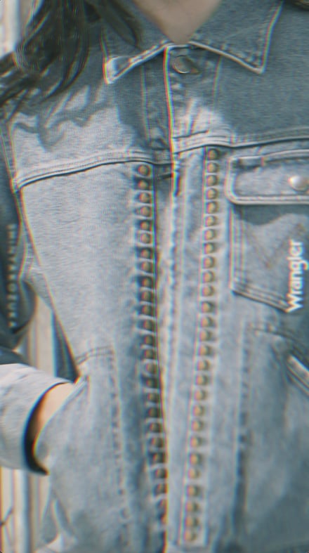 デニムのジャケットを着用したモデルの胸元