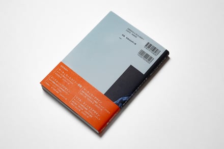 オレンジの帯を付属した黒と青を基調とした本の裏表紙