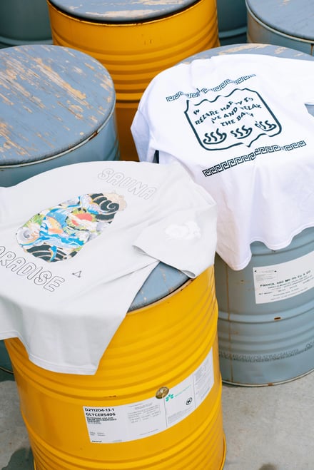 水色や黄色のドラム缶の上に置かれた白いTシャツ