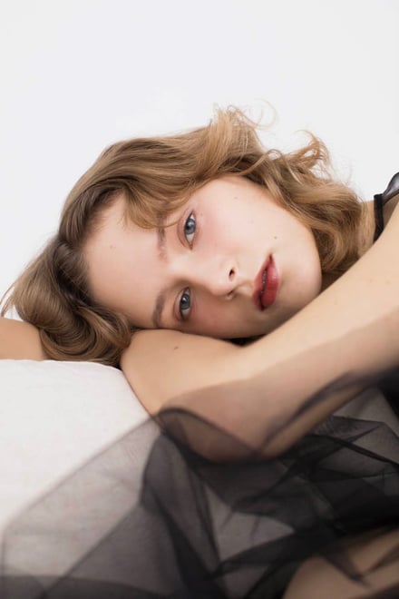 枕に横たわる女性モデルの画像