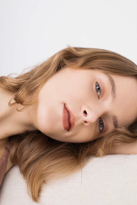 枕に横たわる女性モデルの画像