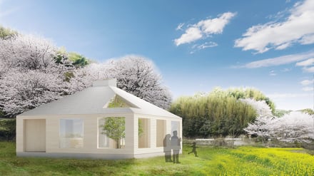 桜を背景にした白い壁のグランピング施設の外観イメージ