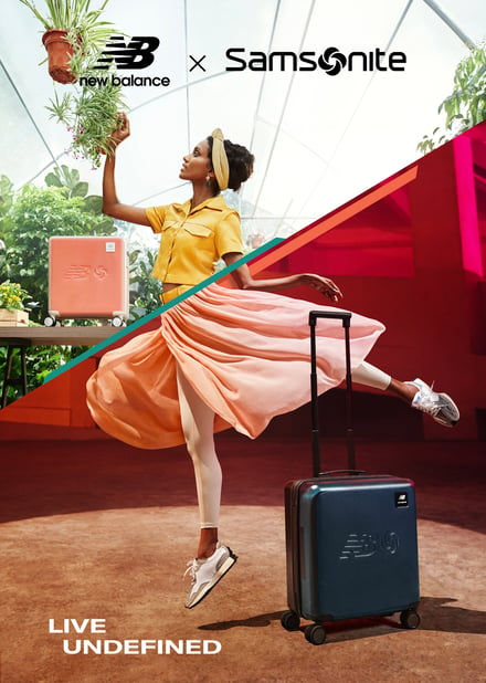 ネイビーのスーツケースの横でダンスをする女性