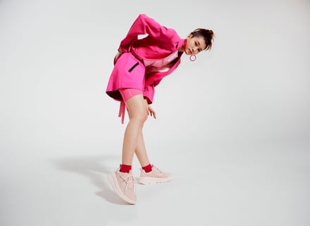 ピンクのジャケットとショーツのセットアップと白いスニーカーを着用した生見愛瑠