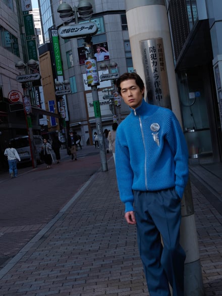渋谷の街並みの中に立っている男性