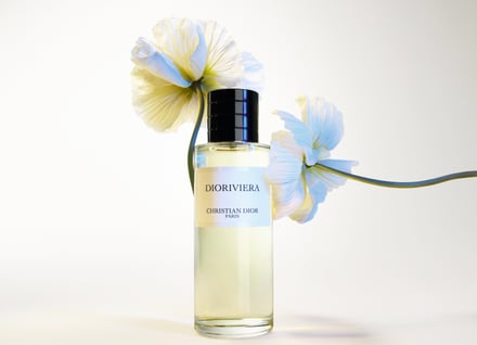 白い花を背景に上品な香水ボトルが置かれている