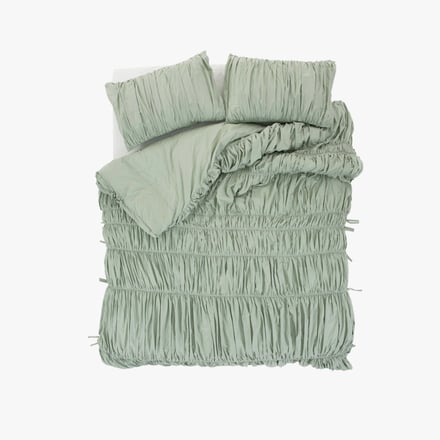 ミントグリーンの布団カバーをかけたベッド