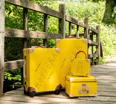 プーさんのイラストをプリントした黄色のスーツケース
