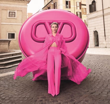 キャンペーン画像　全身ピンクのモデルが巨大なファンデの前に立っている