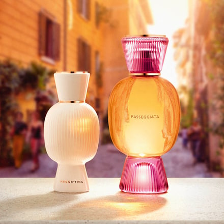 イタリアの夕焼けの街並みの中に配置された大小の香水瓶