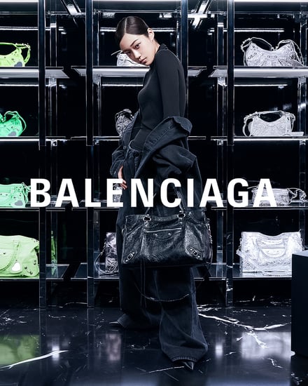 バレンシアガのバッグが陳列された棚の前に立つ女性モデル