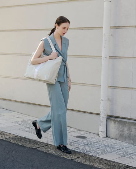 グレーのトートバッグを持った女性