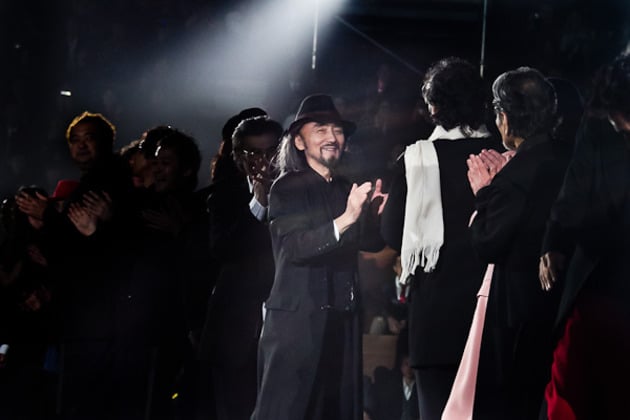 ファッションショー終了後にモデルに拍手を送るデザイナーの山本耀司