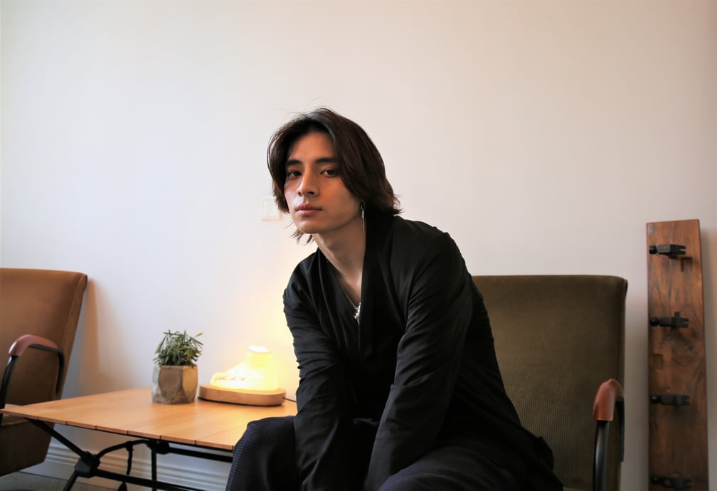 ソファに座りポーズをとる羽生田挙武