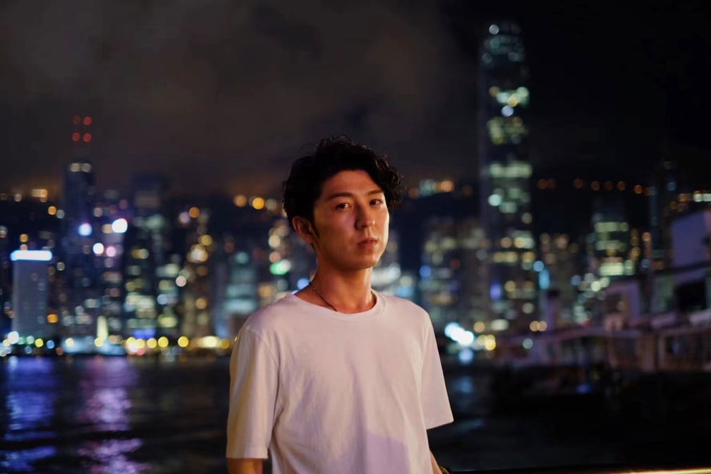 上海の夜景をバックに撮影した西山氏
