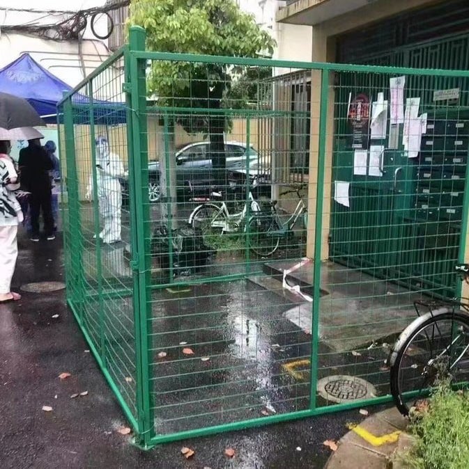 緑色のフェンスで囲まれた住居