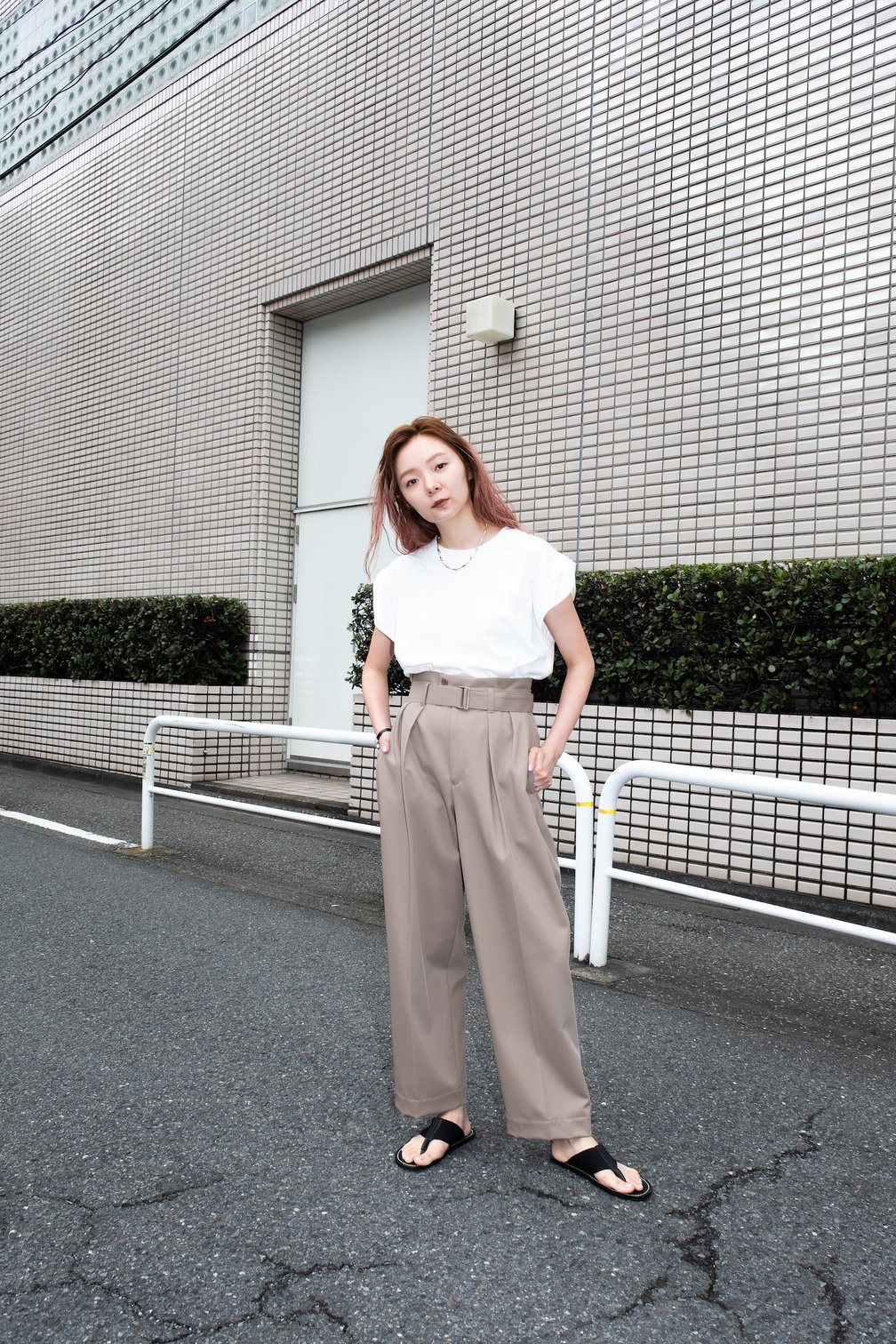 ベージュのパンツに白Tを合わせた女性モデル