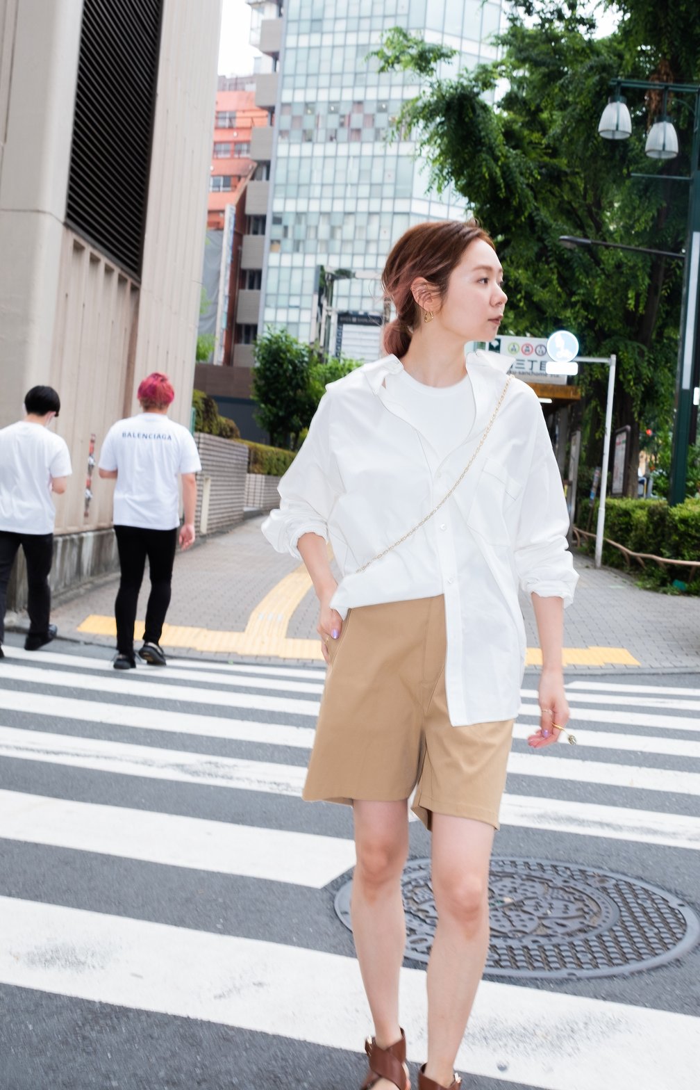 白シャツとベージュのハーフパンツを着用した女性モデル