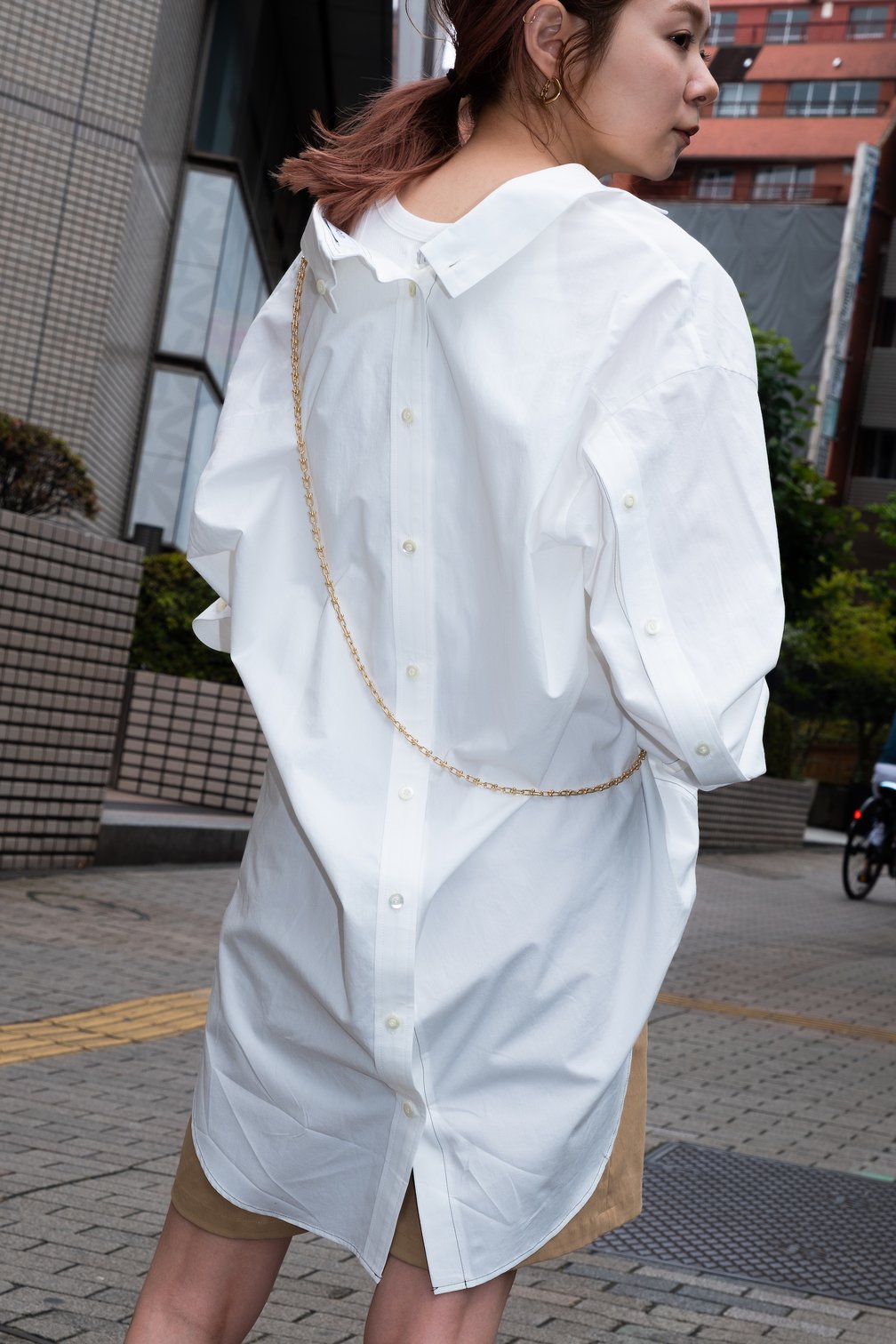 背中と袖にボタンがあしらわれた白シャツ