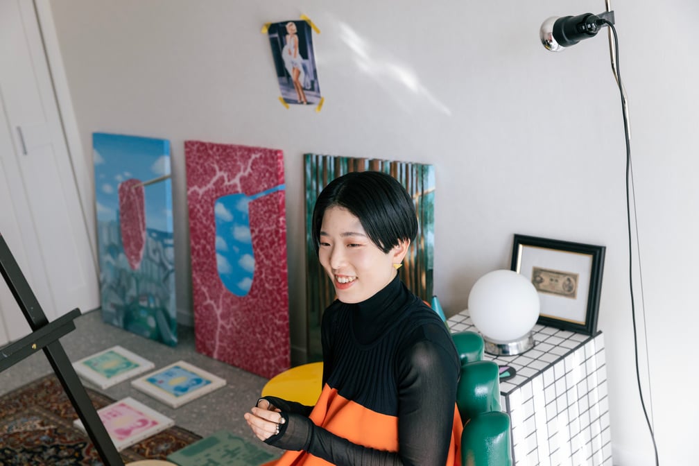 箸で持ち上げられた生肉を描くアーティスト田辺