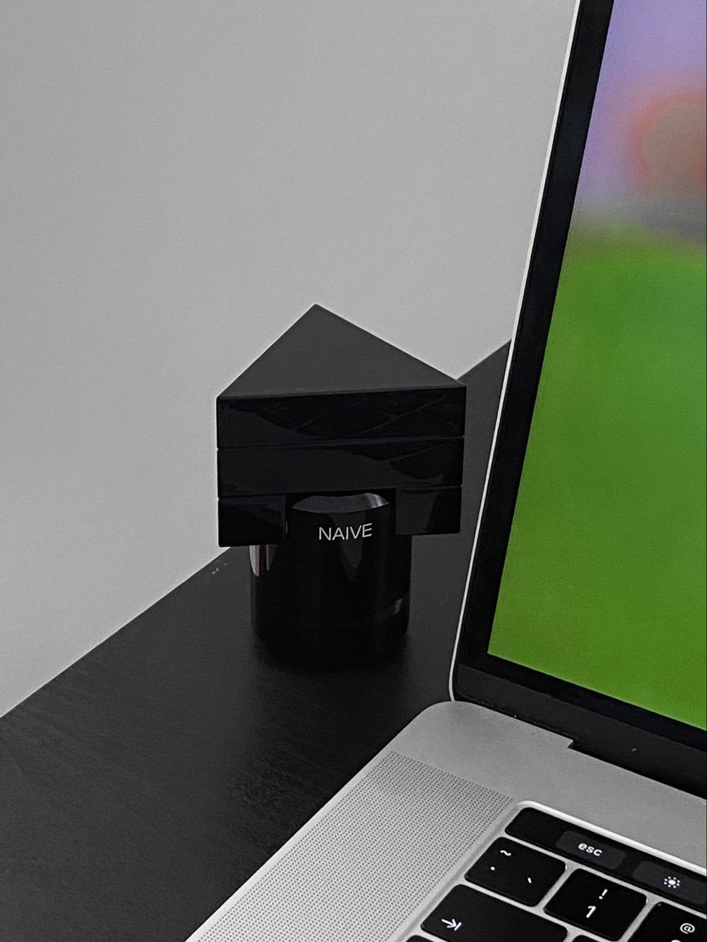 黒い三角形のフレグランスボトルとパソコン