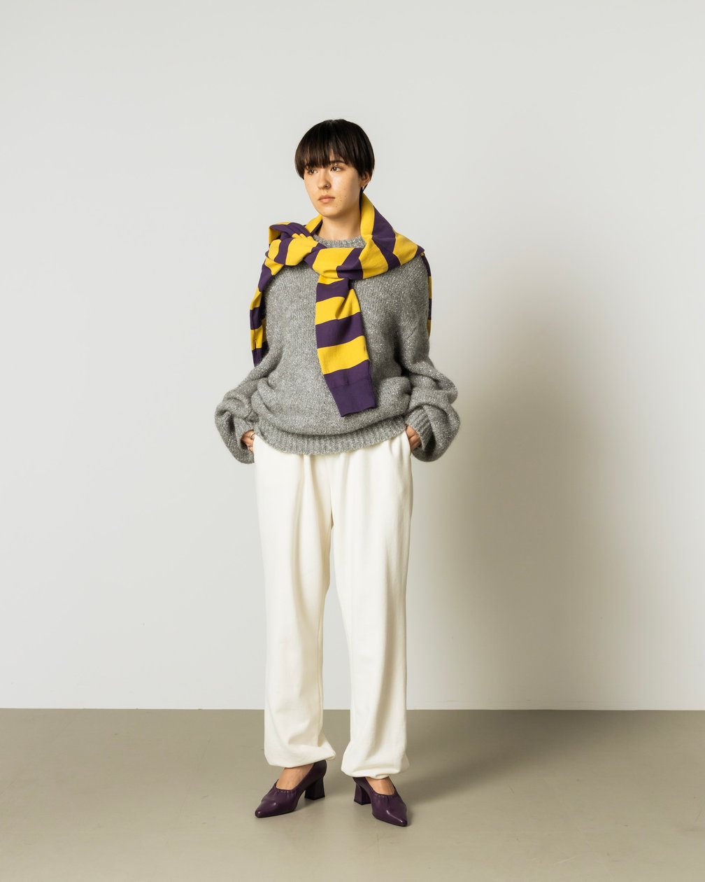 シルバーのラメニットとスウェットパンツ を合わせた女性モデル