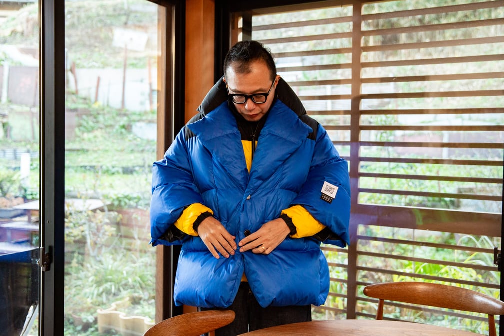 青いダウンを着る男性