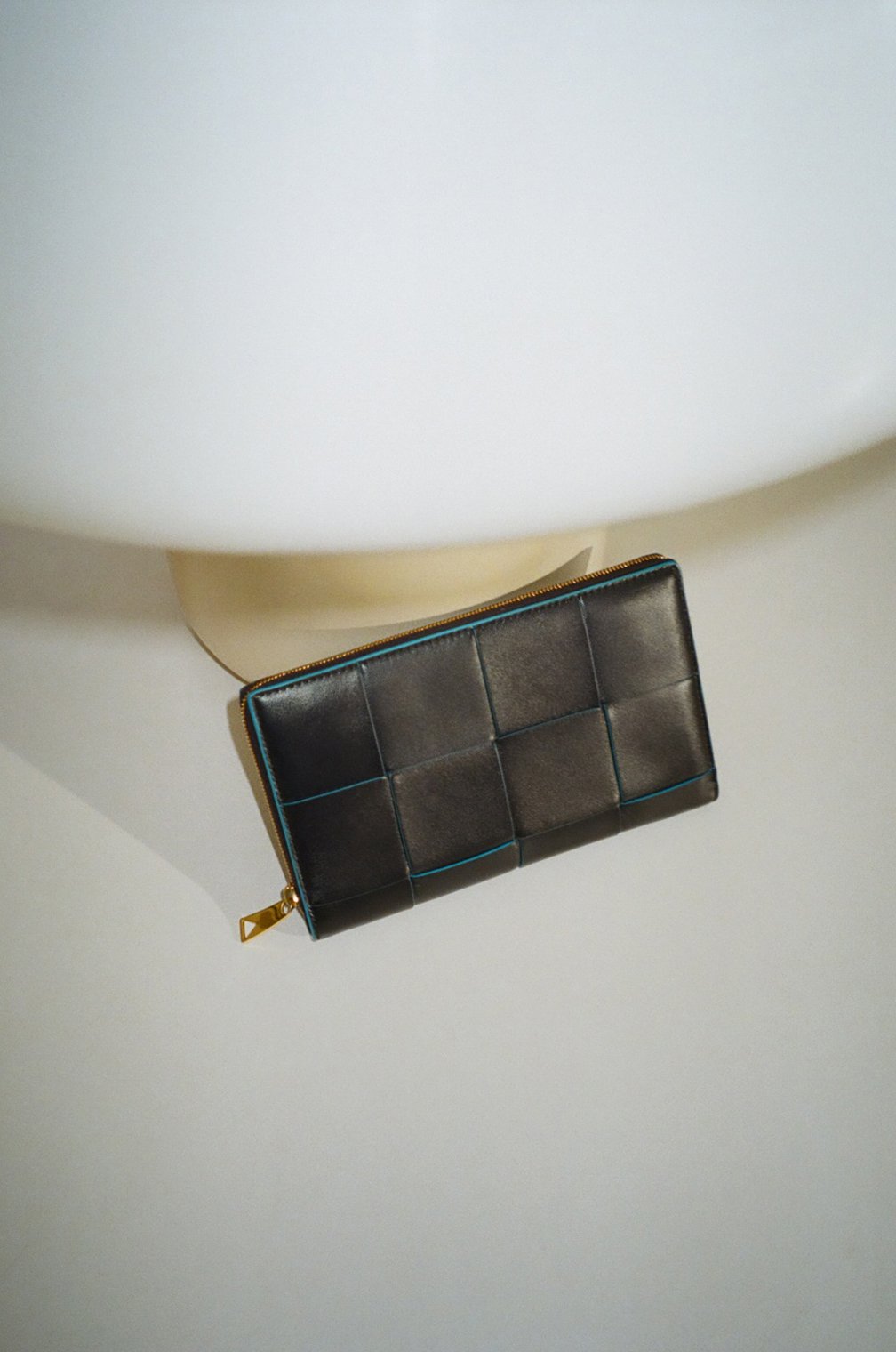 編み込まれたレザーのリムから鮮やかなブルーを覗かせて。ウォレット(SPACE-POOL)(H11.5×W19×D2cm)15万4000円(日本限定色)