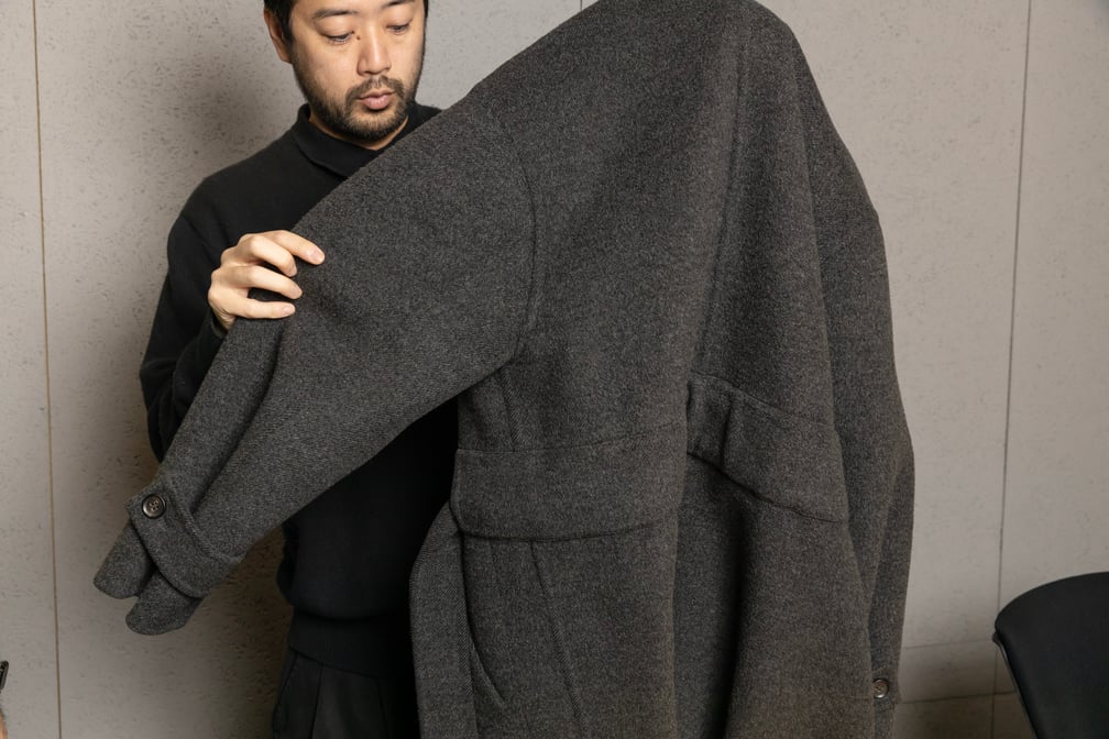コートを解説する男性デザイナー