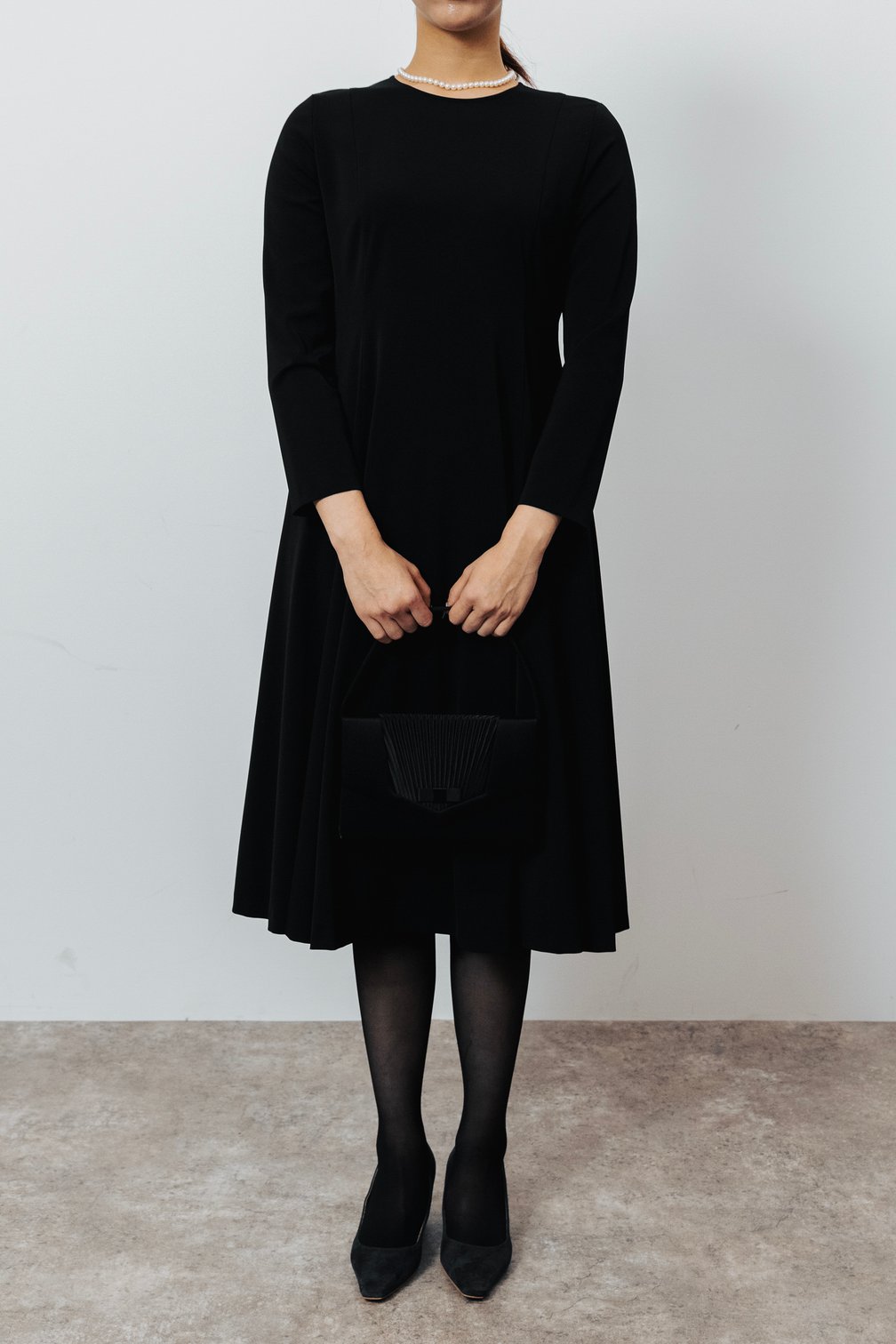 黒いワンピースとタイツを着用した女性