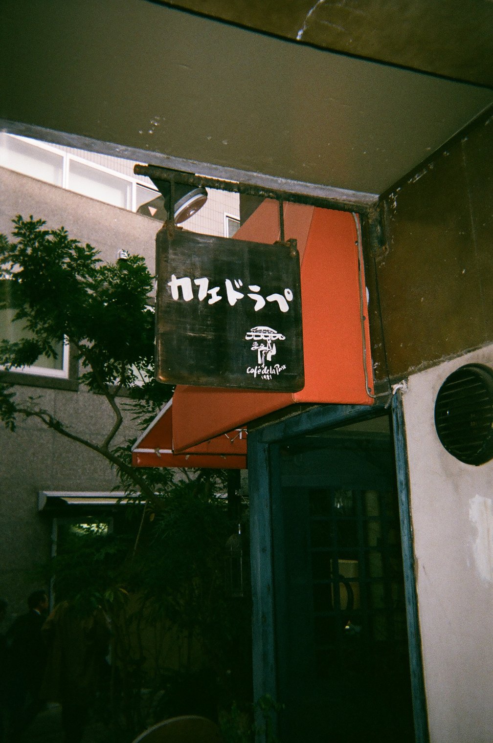 カフェの名前が白い文字で書かれた木の看板