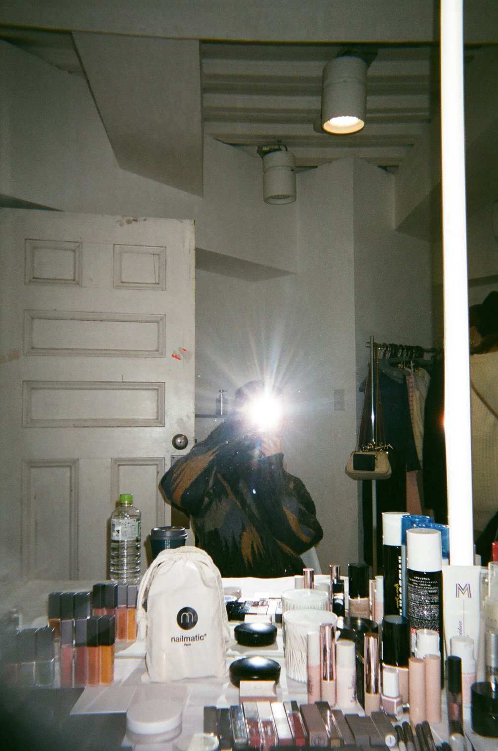 鏡越しでフラッシュを焚き写真を撮影する女性