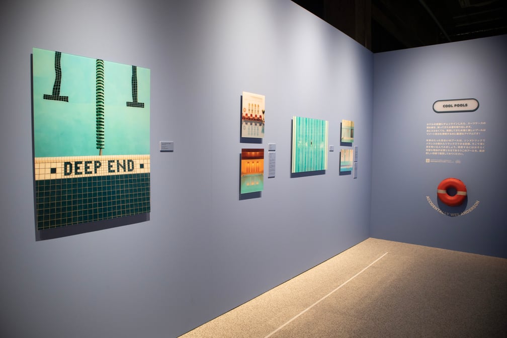 青い壁に写真作品が展示された展覧会内部